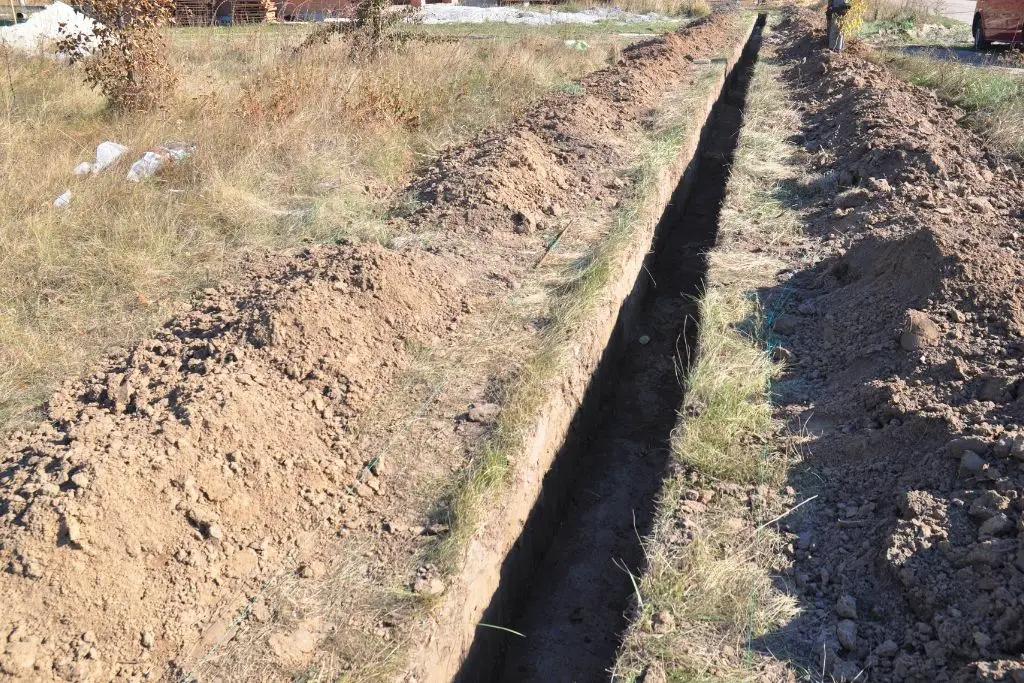 DIG A TRENCH TO HELP DIVERT WATER AWAY FROM THE CHICKEN RUN.